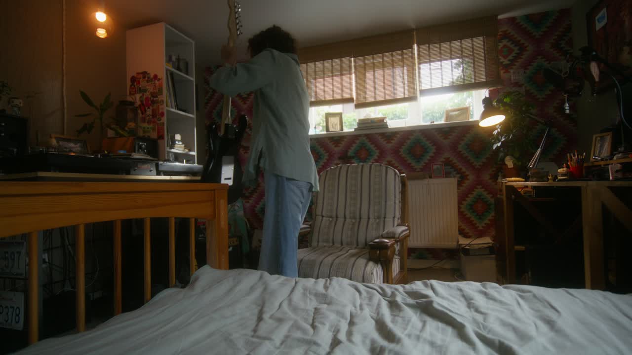 쾌적 한 침실 에서 전기 기타 를 연주 하는 십대 소녀