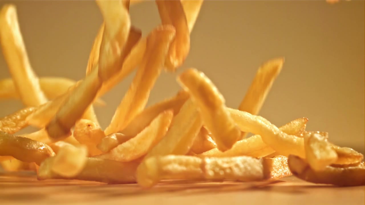 Crispy Golden French Fries Falling in Slow Motion