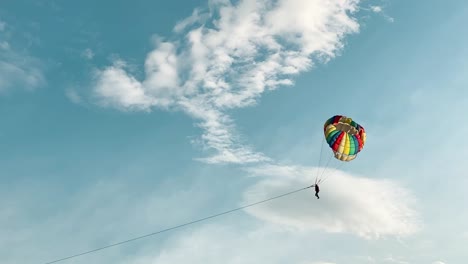 Disparo-En-Cámara-Lenta-Muy-Lejos-De-Paracaidista-De-Parasailing-Con-Paracaídas-Colorido