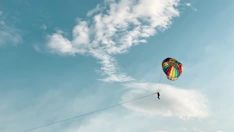 amplia lejana toma en cámara lenta de paracaidista silueta con paracaídas colorido
