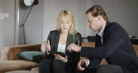 Business-People-Using-Digital-Tablet-On-Sofa-In-Office