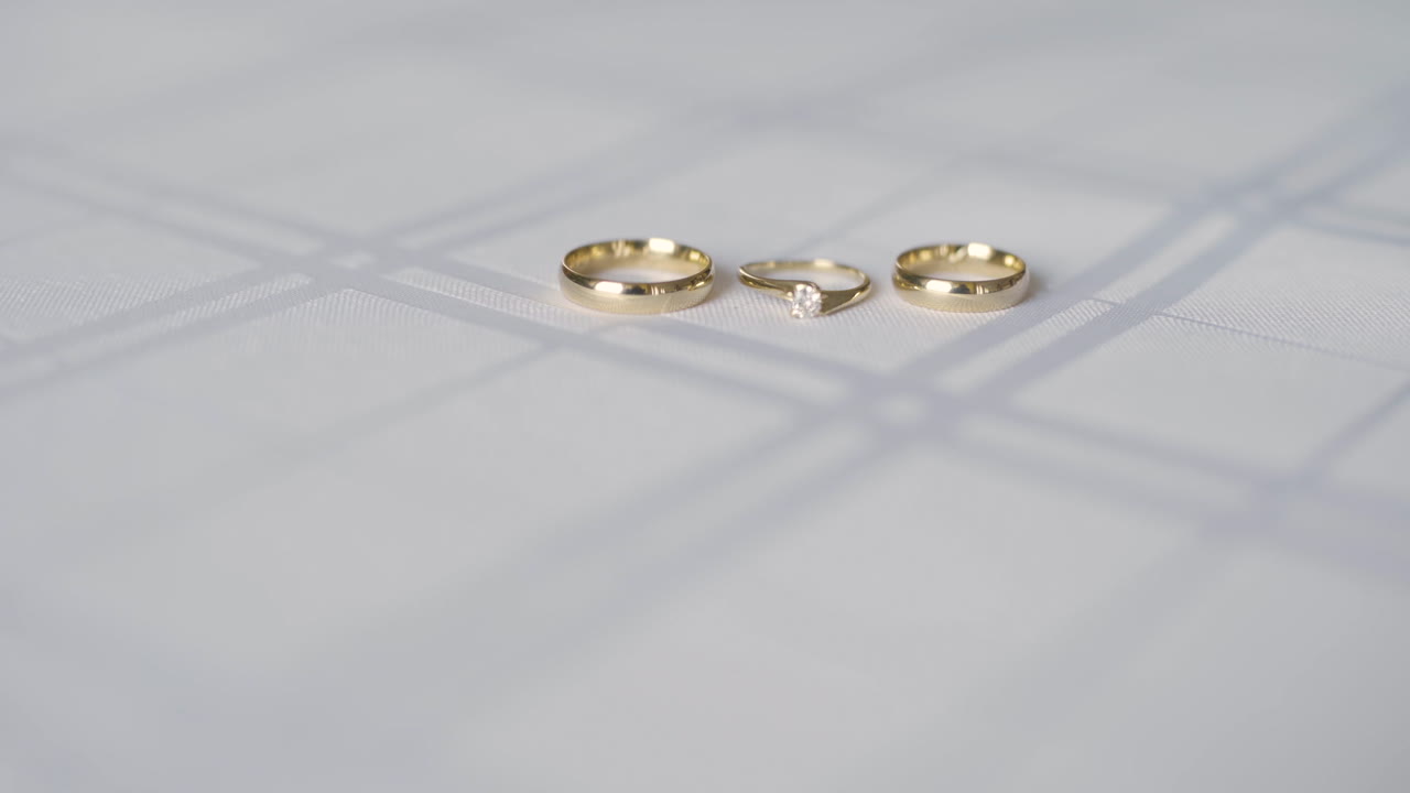 Primo piano di fedi nuziali d'oro e anelli di fidanzamento con diamante