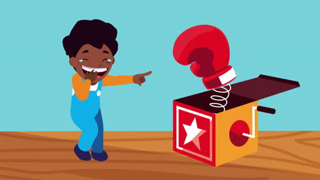afro little boy giggling with boxing glove in surprise box
