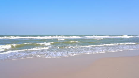 waves spread along the sand of a deserted beach