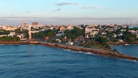 obelisco en juan baron plaza y parque de diversiones a lo largo del malecón al amanecer, santo domingo en república dominicana