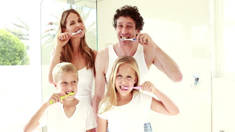 familia feliz lavándose los dientes juntos