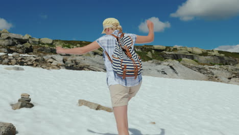 una mujer camina sobre la nieve en las montañas afuera es un verano caluroso la nieve no te ha derretido