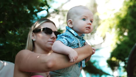 mother holding baby boy in park