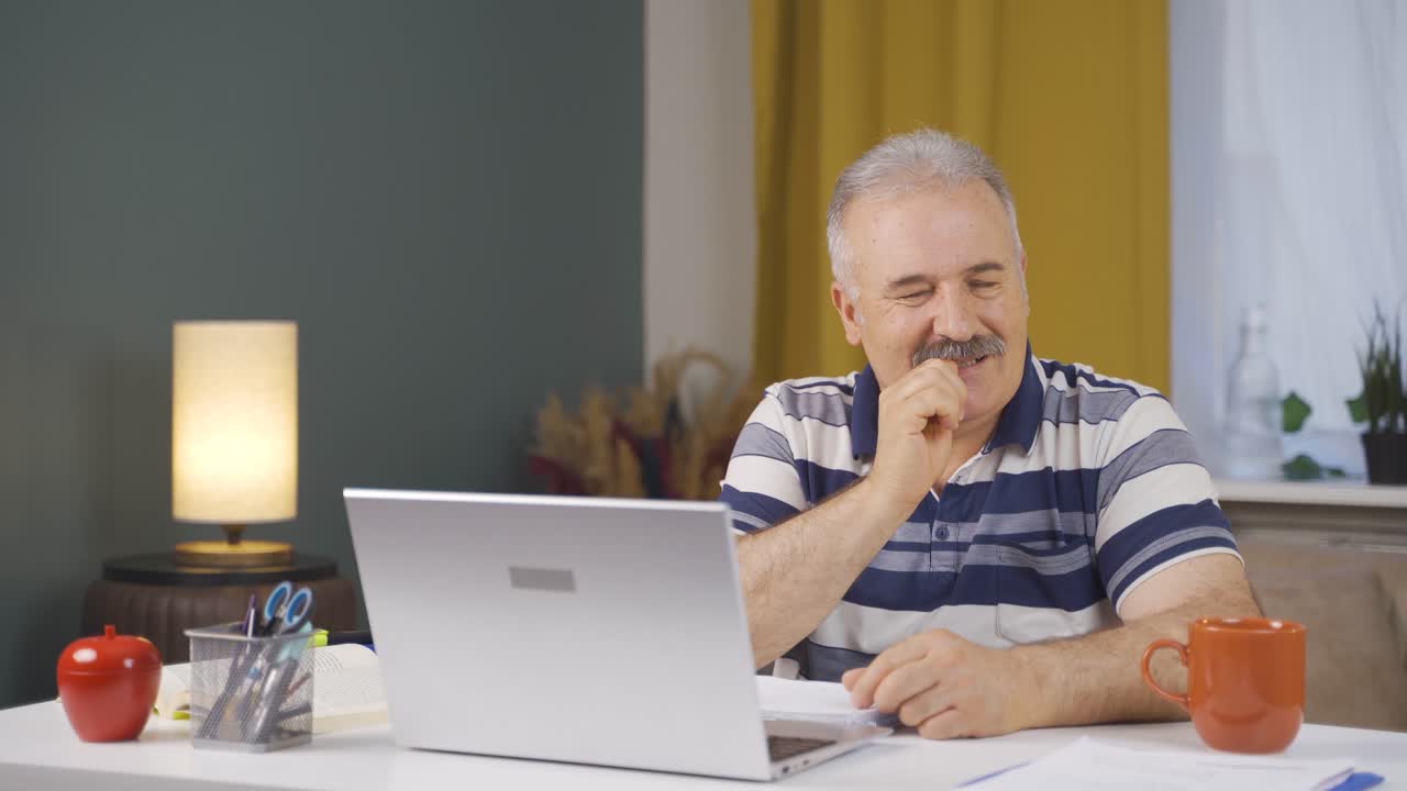 Home office worker old man biting his nails looking at camera.