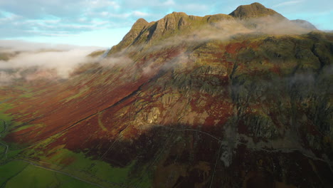 Lightly-misted-mountains-lit-by-early-morning-autumn-sunshine-and-covered-in-dead-bracken