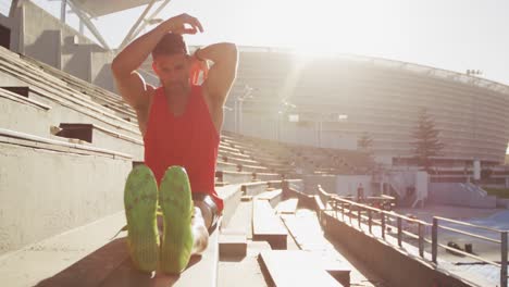 Caucasian-athlete-stretching-in-stadium