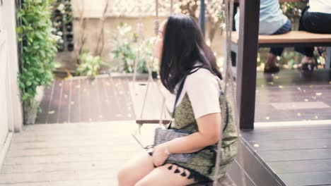 woman drinking coffee on a swing