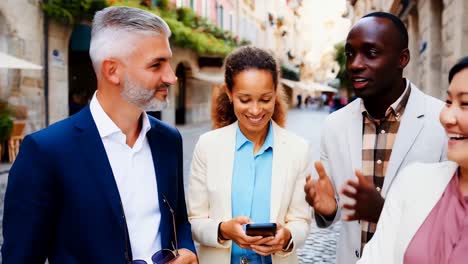 three people are standing on a street, one of them is holding a cell phone