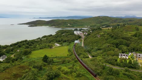 aerial view of the jacobite steam train crossing through morar in scotland, west coast of scotland