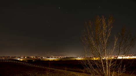 Estrellas-Y-Senderos-De-Luz-De-Aviones-Que-Cruzan-El-Cielo-Nocturno-En-Un-Lapso-De-Tiempo-De-La-Comunidad-Suburbana