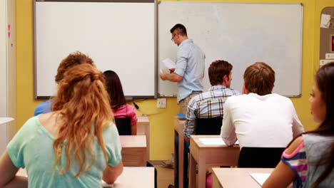 profesor escribiendo en la pizarra en clase