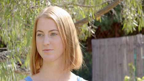 standing outdoors in garden, woman looking away thoughtfully