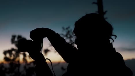 Silhouette-Eines-Langhaarigen-Mannes,-Der-Abends-In-Guatemala-Mit-Einer-DSLR-Kamera-Ein-Foto-Vom-Vulkan-Fuego-Macht