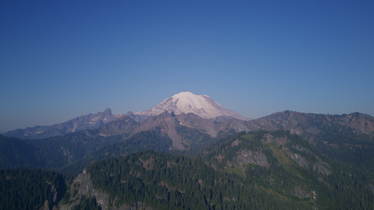 Riprese aeree delle montagne intorno al Monte Rainier con una grande montagna innevata sullo sfondo