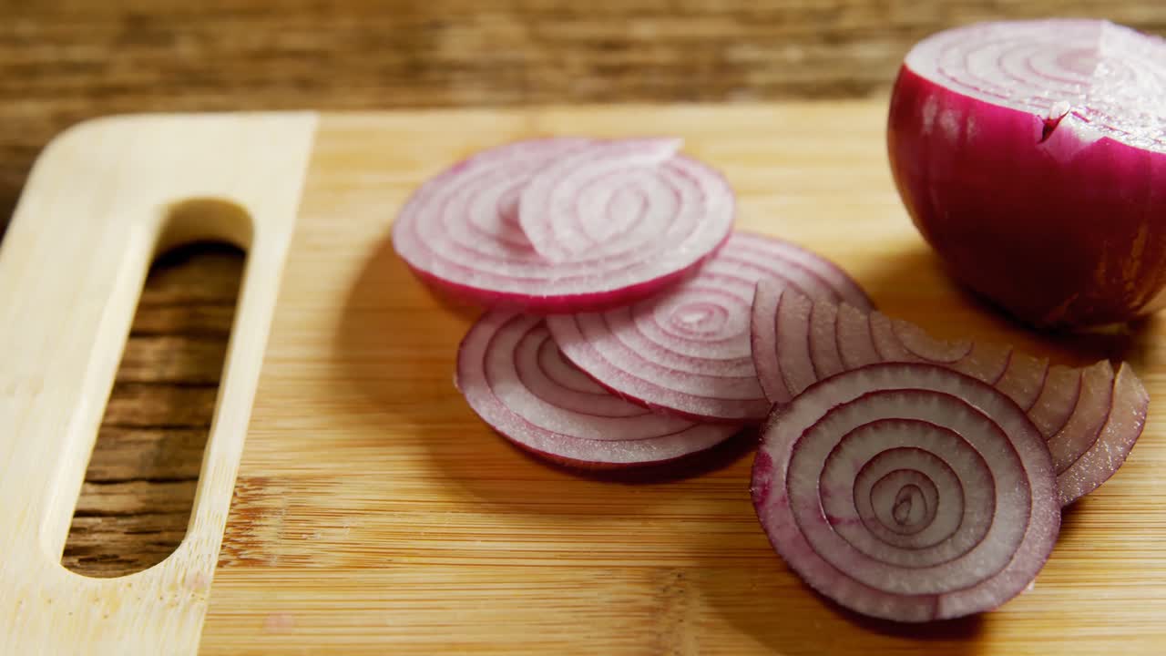 Sliced and halved onions on chopping board 4k