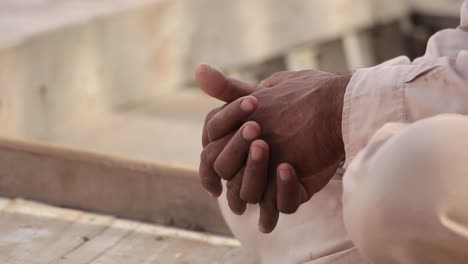 closeup of a man in traditional pakistani dress clasping hands