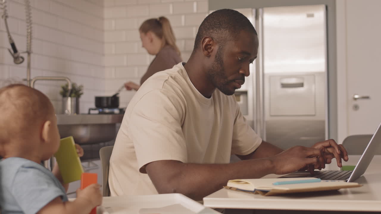 Father Working Next to Baby