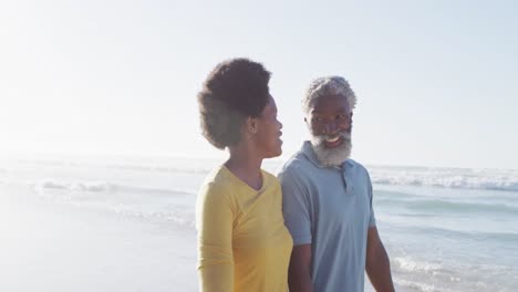 Feliz-Pareja-Afroamericana-Caminando-Y-Hablando-En-La-Playa-Soleada