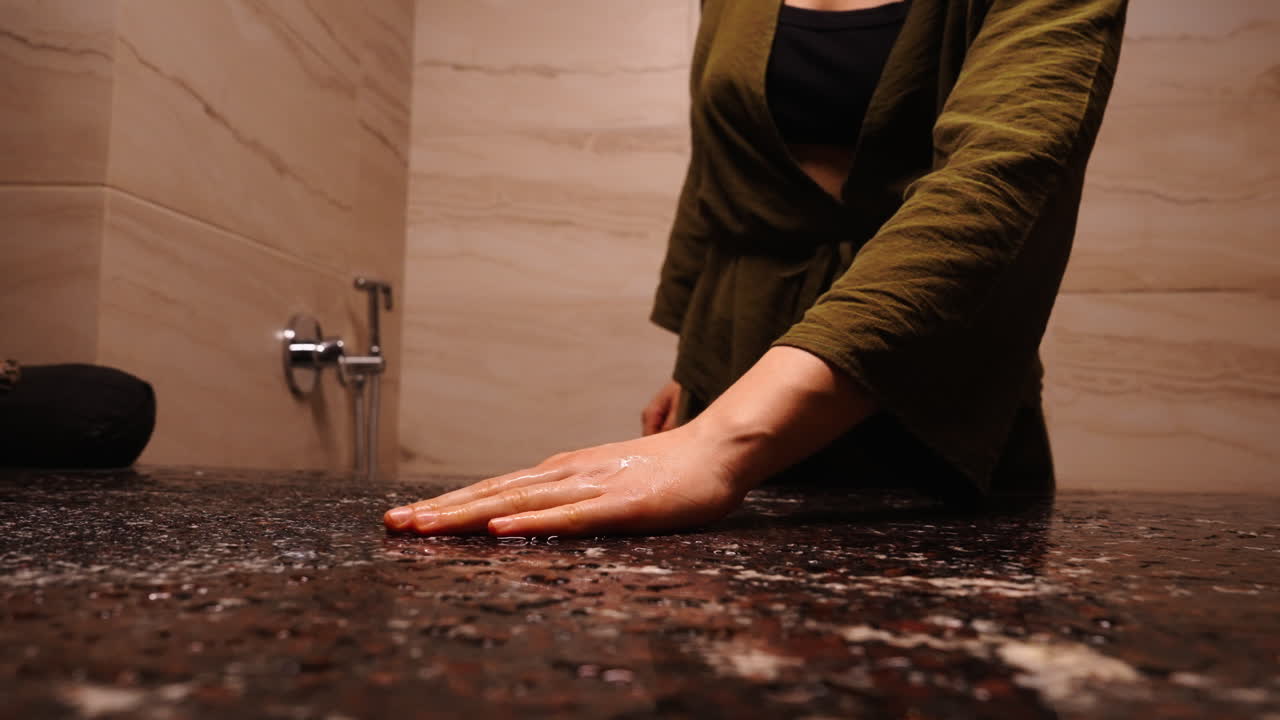 Woman in a spa, touching water on a stone table