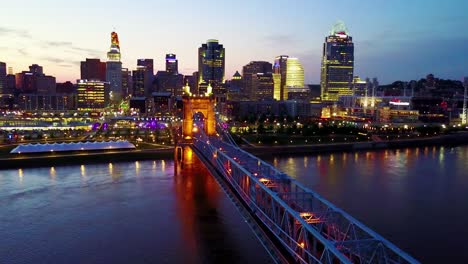 Una-Hermosa-Toma-Aérea-De-La-Noche-De-Cincinnati,-Ohio,-Con-El-Puente-Que-Cruza-El-Río-Ohio-En-Primer-Plano-11