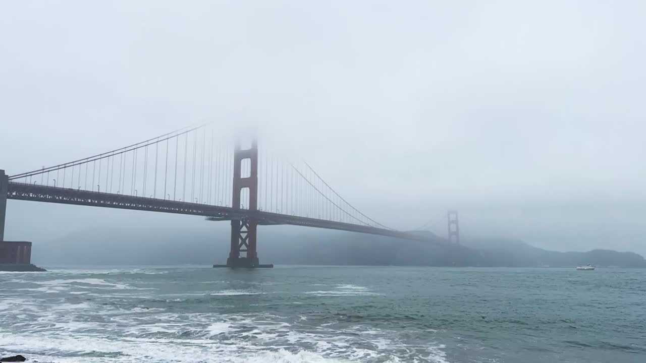 San Francisco California Golden Gate Bridge, timelapse moving waves in foggy weather boats and seagulls in view STATIC SHOT