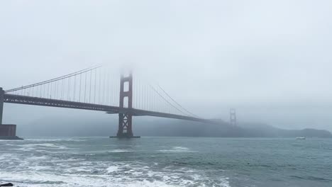 san francisco california golden gate bridge, timelapse moving waves in foggy weather boats and seagulls in view static shot