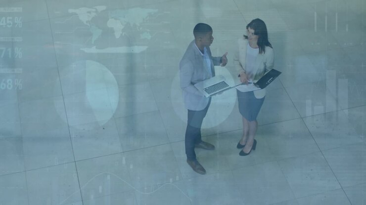 Un gruppo eterogeneo di professionisti che parlano e usano i laptop nella hall di un ufficio moderno