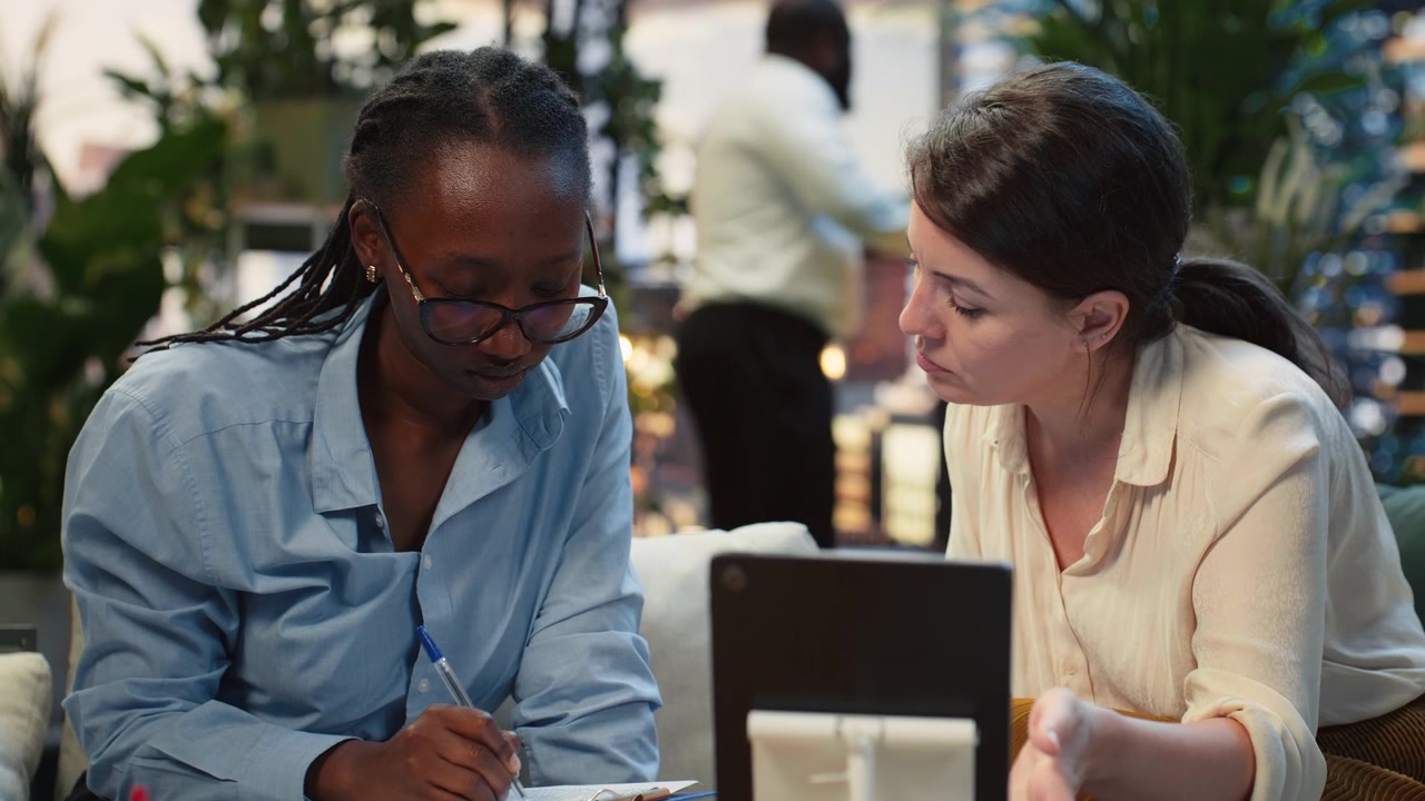 Close up of businesswoman takes notes on clipboard during rooftop conversation