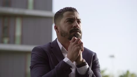 hombre de negocios emocionalmente nervioso orando al aire libre