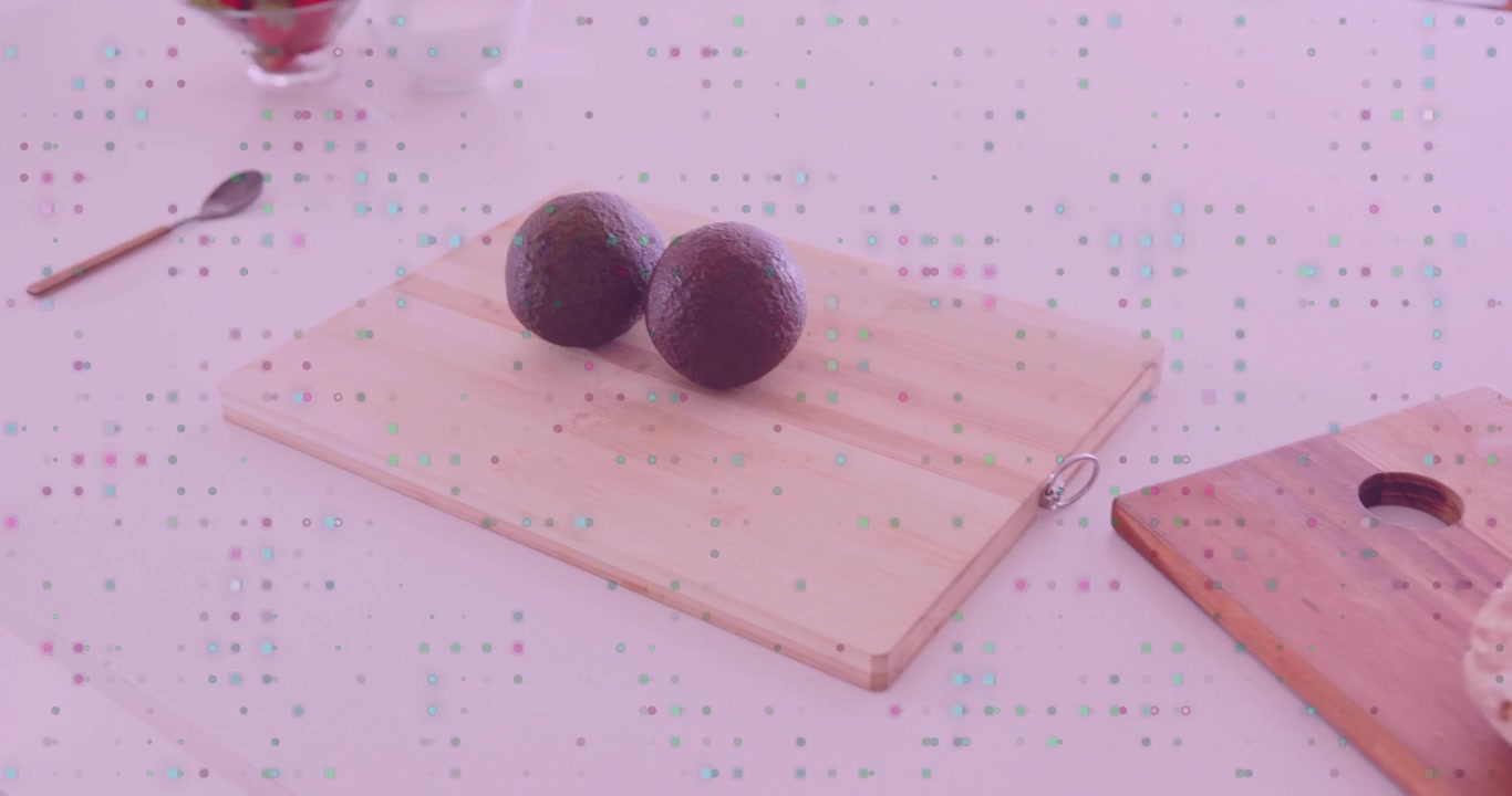 Camera panning left revealing two avocados entering, centering on light board beside bread, berries