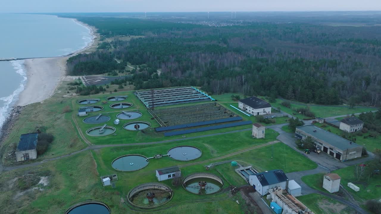 Establishing aerial view of water basins at the sewage treatment plant, ponds for recycling dirty wastewater, recycle system technology, waste management theme, drone shot moving forward, tilt down