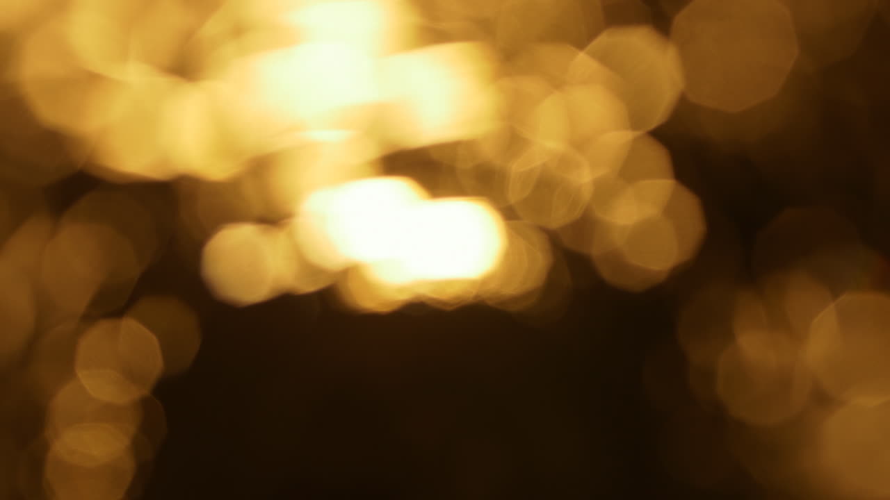 Luci bokeh dorate astratte scintillanti su sfondo scuro