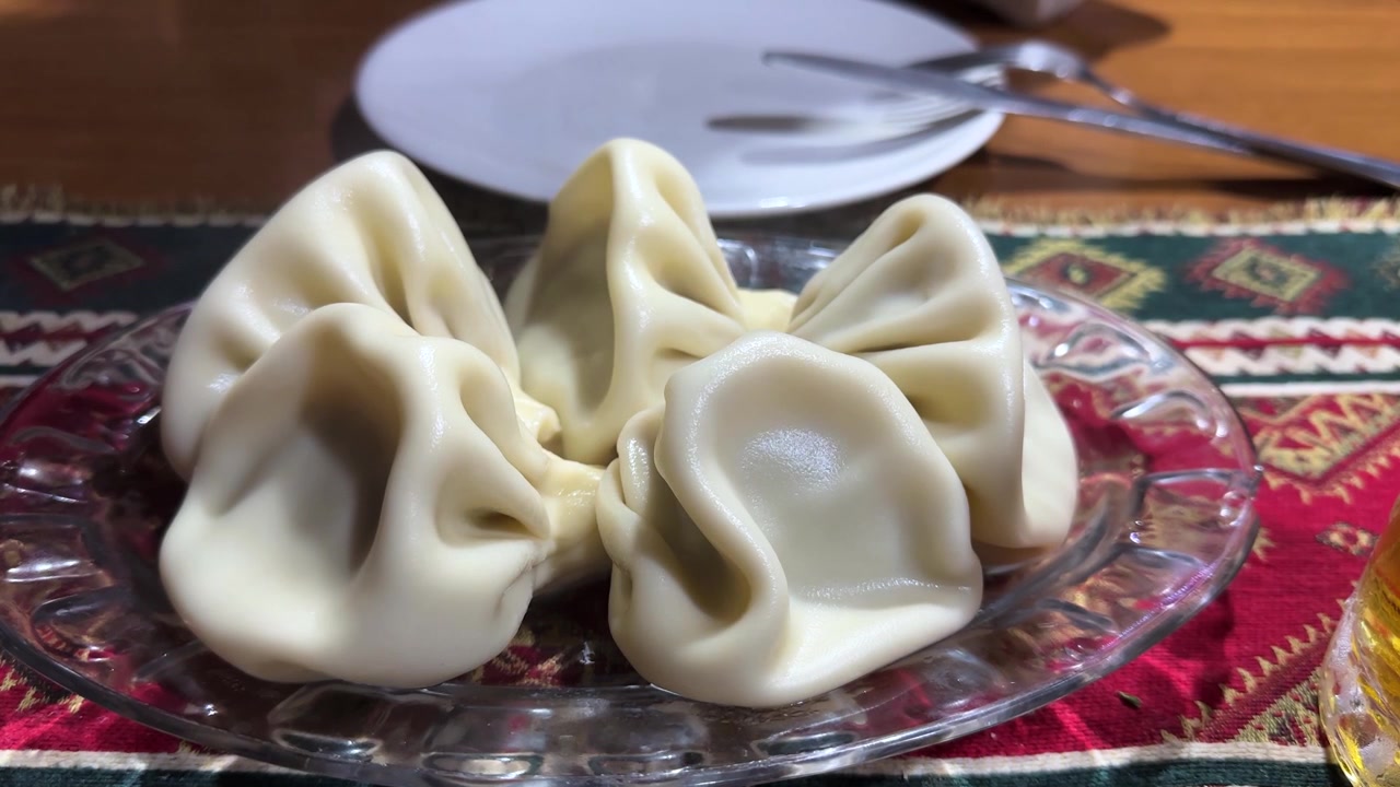 Georgian cuisine dumpling dough boiled in hot khinkali Caucasus meat chopped vegetable minced mix delicious plate local food Tbilisi dining table traditional mountain region savory seasoned pork beef