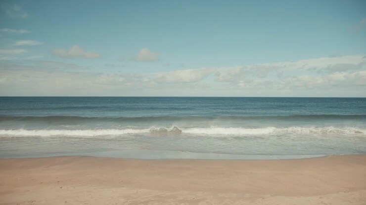 Wide Shot of Calm Ocean Waves on a Sandy Beach