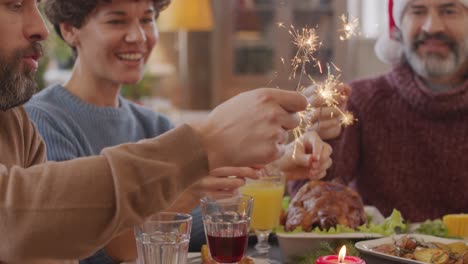 Familia-Sentada-A-La-Mesa-En-La-Comida-De-Navidad-Con-Bengalas