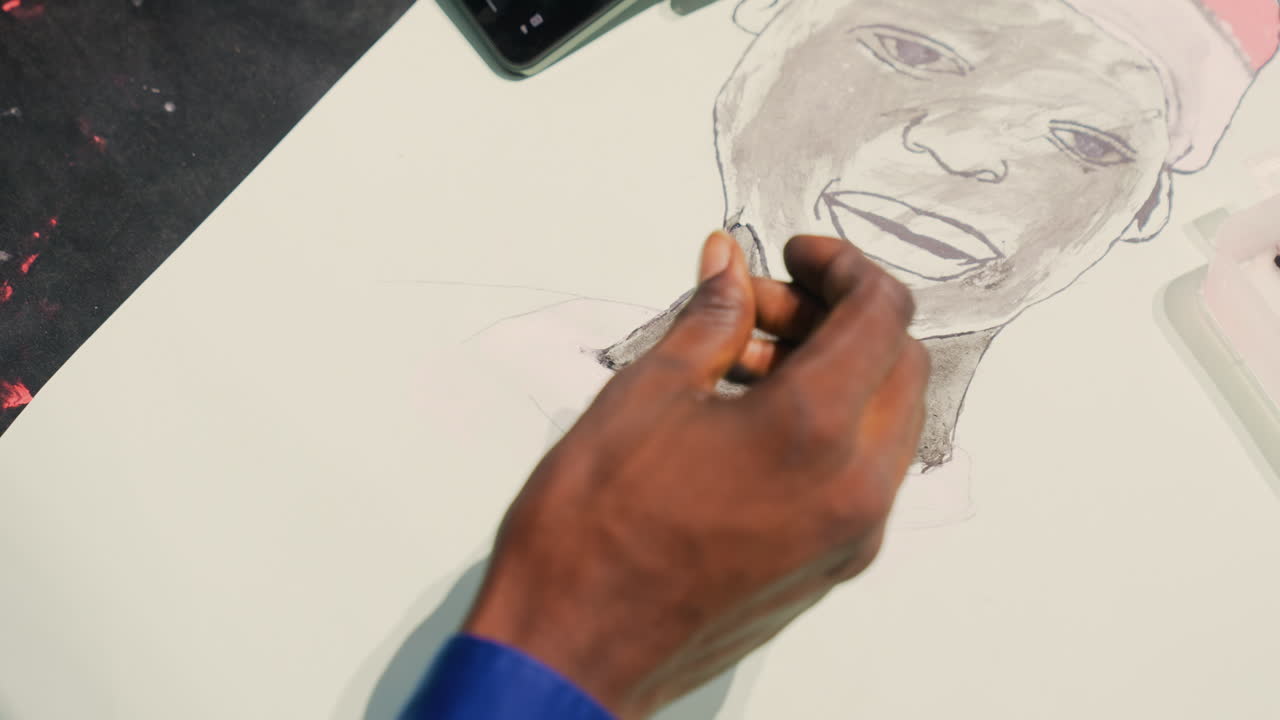 Black man portrait neck shading demonstration with fingertip and brush, instructor blending charcoal into paper, classroom workshop lighting, smiling subject wearing cap, handson lesson atmosphere