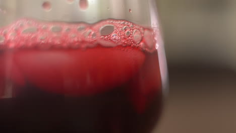 verter un vaso de agua de jamaica sobre hielo - una bebida de flor de hibisco seca de méxico