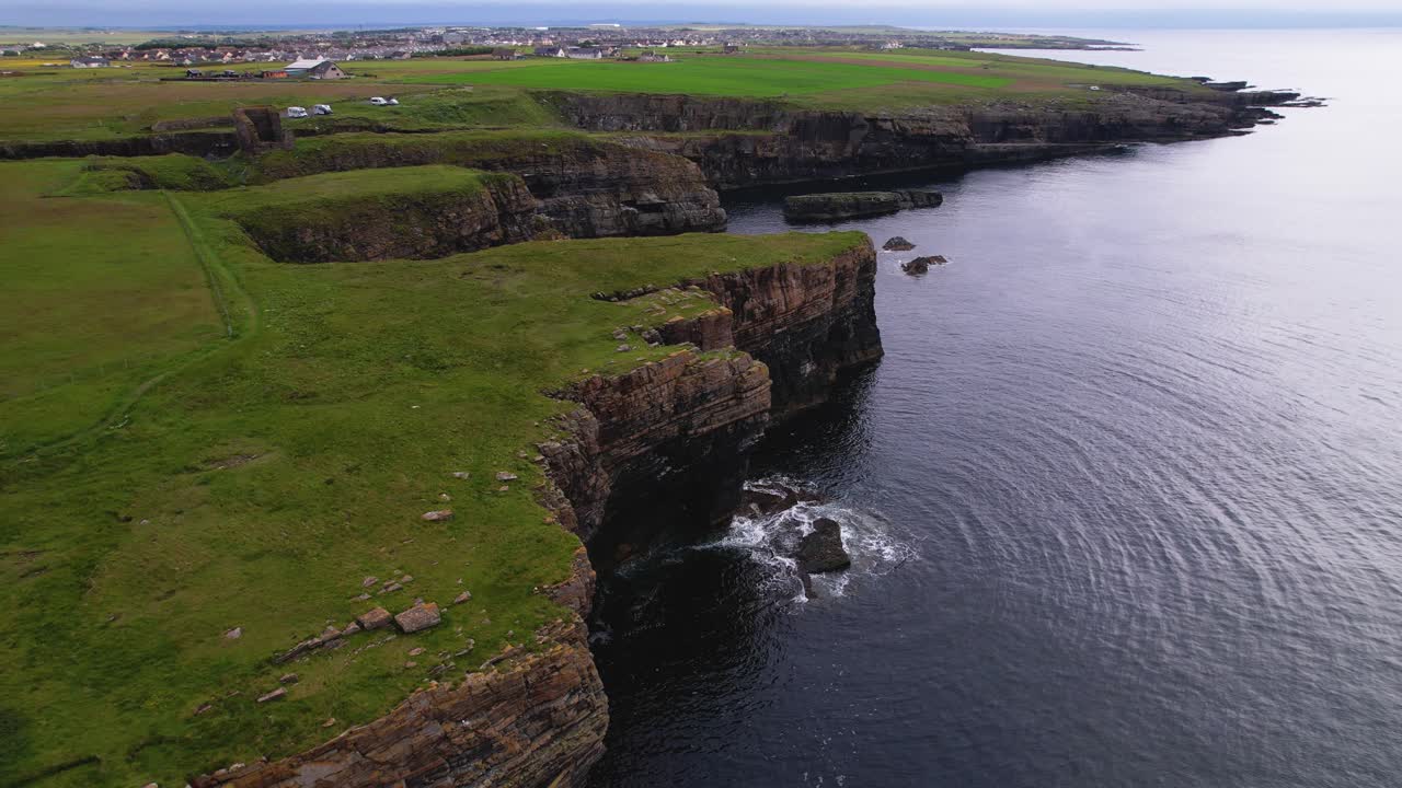 Scottish cliffs by the sea with lush green grass and peaceful vibes, aerial view