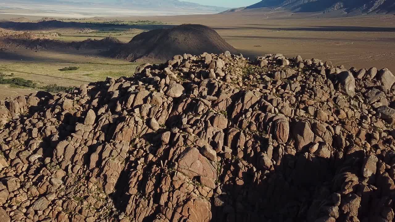 vista aérea cinematográfica sobre la formación rocosa en el valle bajo las colinas de alabama, california