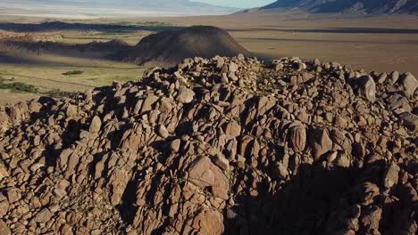 vista aérea cinematográfica sobre la formación rocosa en el valle bajo las colinas de alabama, california
