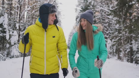 amar a un hombre y una mujer en cámara lenta en invierno esquiando en el bosque. día de san valentín