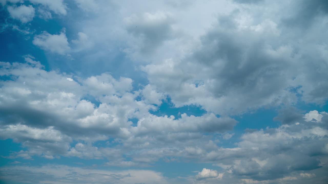 Tamlaps blue sky with several layers of fast moving cumulus clouds. Summer fluffy clouds