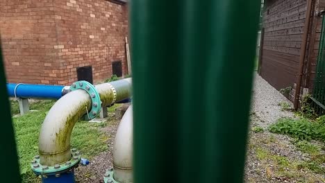 british clean water supply industrial distribution pipes at utilities substation secured behind metal fence