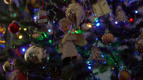 angel with dirty face christmas decoration hanging on tree with lights