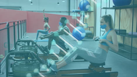 dna structure spinning against caucasian woman wearing face mask performing rowing exercise at gym